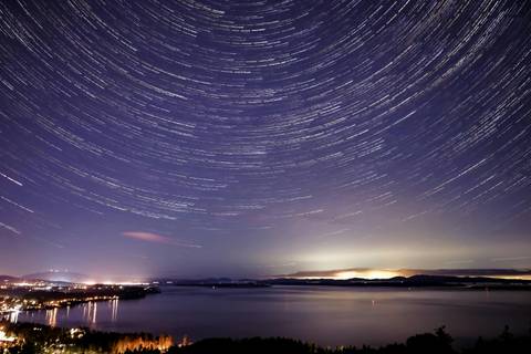 Glowing Lights Of City On Seashore Under Starry Sky - Abstract wallpaper